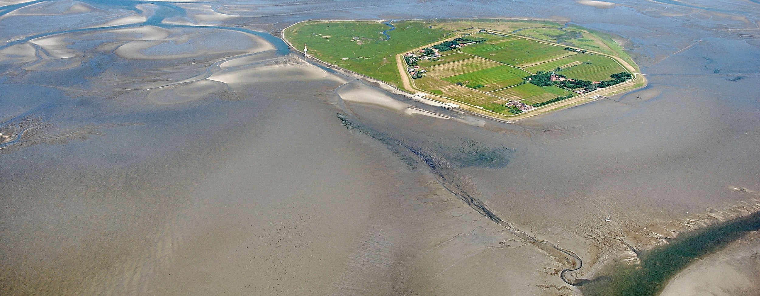 Luftaufnahme der Insel Neuwerk im Wattenmeer mit Warft, Deich und weitläufigem Wattgebiet