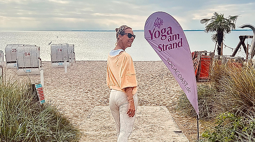 Frau geht zum Yoga am Strand von Scharbeutz und Haffkrug an der Ostsee