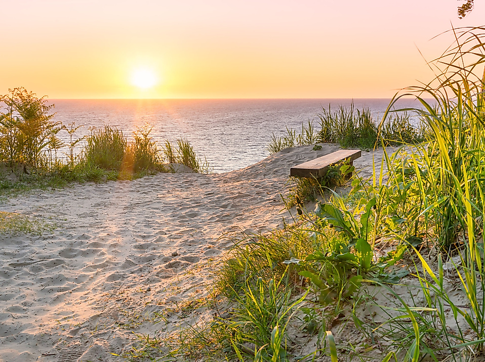 Sonnenuntergang über der Ostsee mit Bank am Küstenpfad – ruhiger Ausblick aufs Meer ab Hamburg