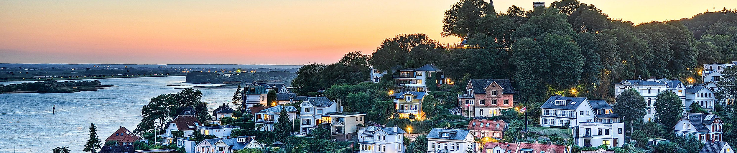 Beleuchtetes Treppenviertel in Blankenese bei Sonnenuntergang mit Blick auf die Elbe und das Uferpanorama