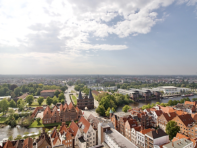 Panoramablick über Lübecks Altstadt mit Holstentor und roten Giebeldächern unter leicht bewölktem Himmel