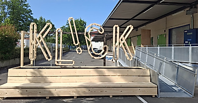 Holzinstallation 'KLICK' vor Gebäude