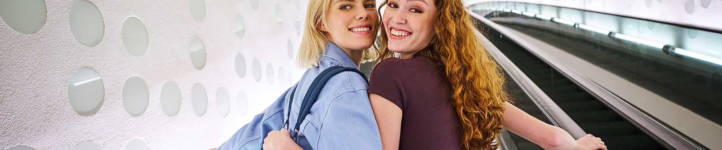Zwei lachende Frauen auf der Rolltreppe der Elphi.