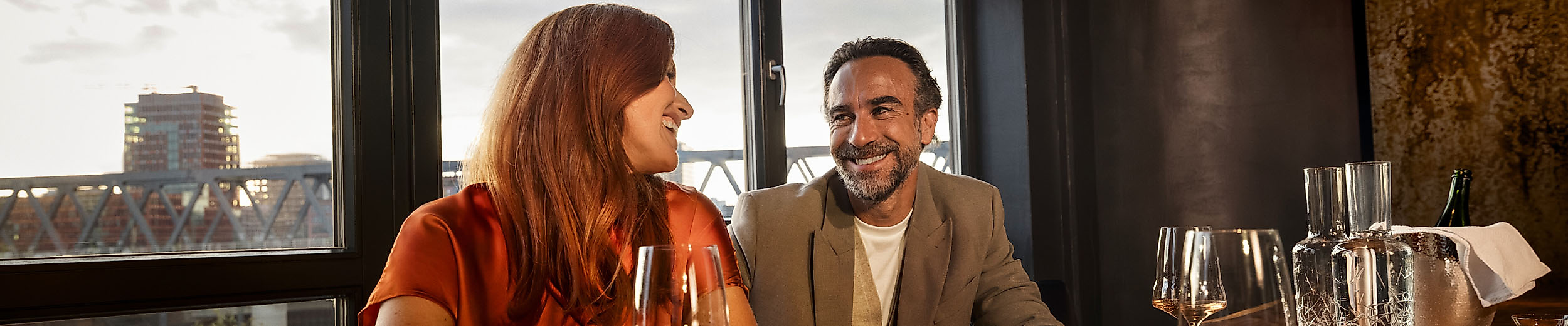 Ein Pärchen sitzt mit einem Glas Wein am Tisch des Restaurants 100/200