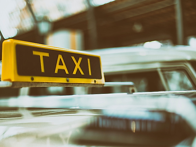 Gelbes Taxischild auf einem Auto, Symbolbild für barrierefreie Taximobilität in Hamburg.