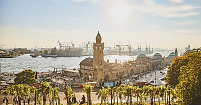 Landungsbrücken mit Uhrturm und Elbe im goldenen Licht der tief stehenden Abendsonne