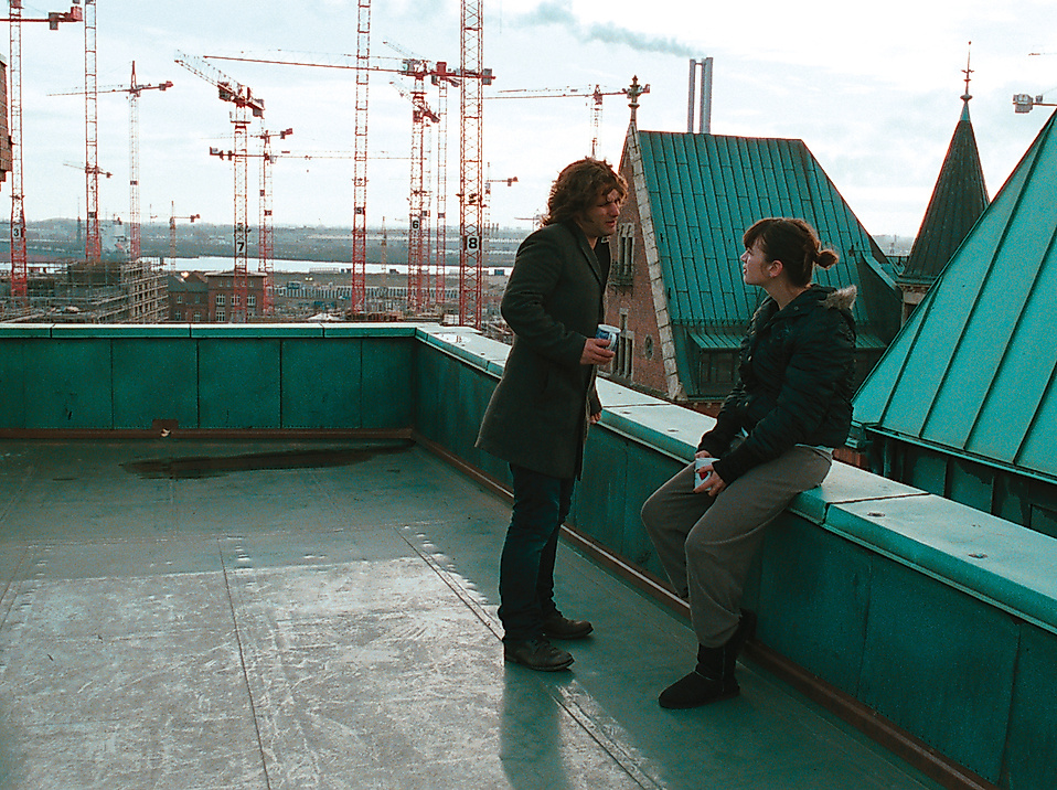 Filmszene aus Soul Kitchen mit zwei Personen auf einem Dach mit Blick über Hamburg