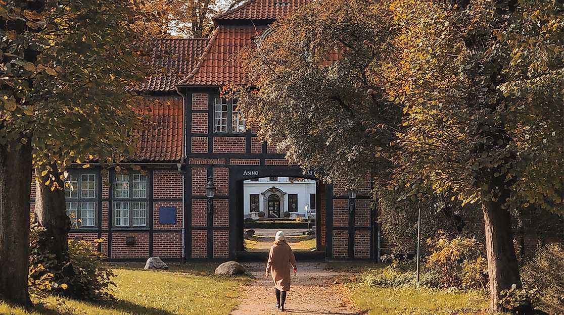 Historisches Wellingsbüttler Torhaus in Hamburg mit Fachwerkfassade, umgeben von Bäumen in herbstlicher Stimmung