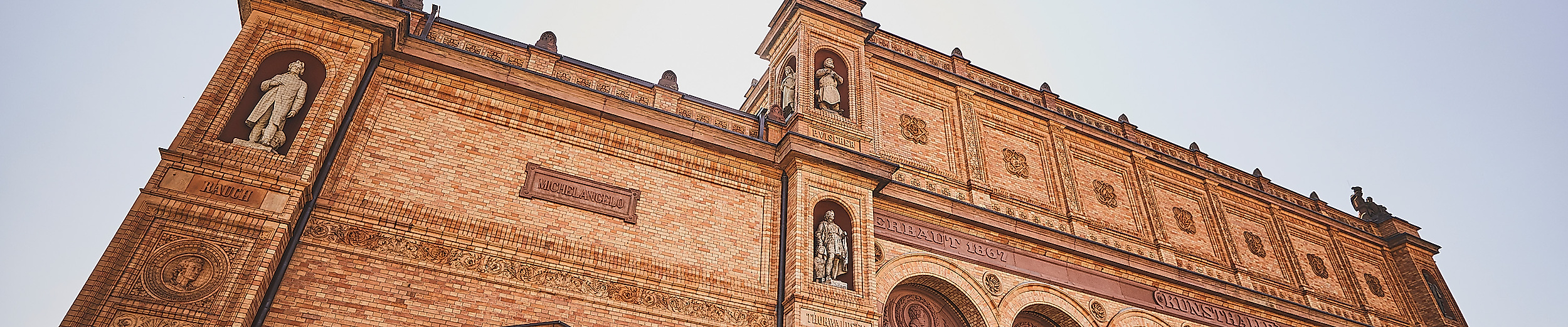 Detailansicht der historischen Backsteinfassade der Hamburgischen Kunsthalle im warmen Abendlicht.