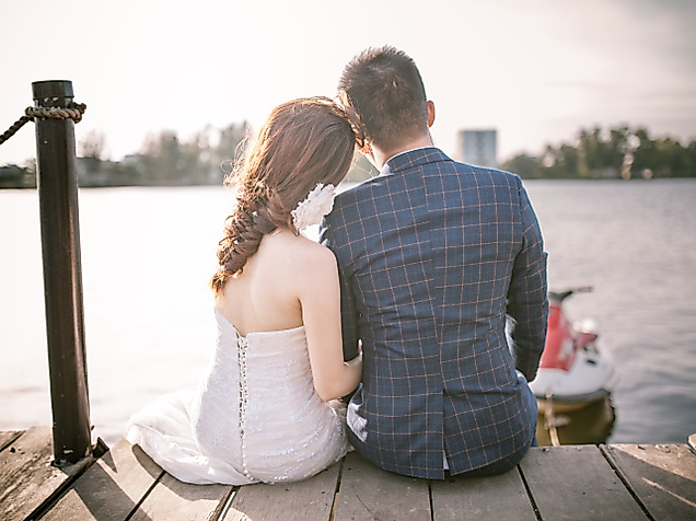 Hochzeitspaar sitzt auf einem Steg am Wasser und genießt einen ruhigen Moment zu zweit in Hamburg