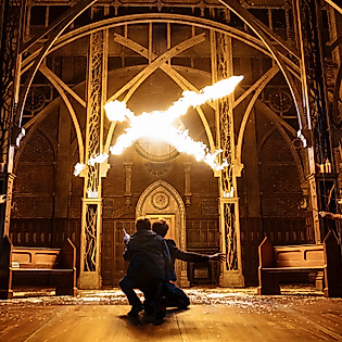 Szenenbild Harry Potter und das verwunschene Kind: Zauberei durch Flammen aus Zauberstäben in einer Halle