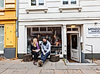 Atelier MoinDori in Hamburg mit zwei Personen auf der Bank vor dem Eingang und kreativem Schaufenster