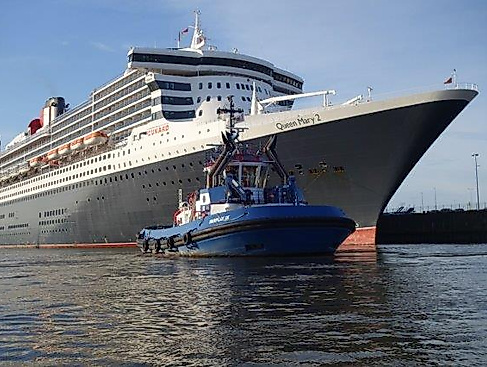 QM2 mit Schlepper vorne - Foto Hans-Jürgen Müller