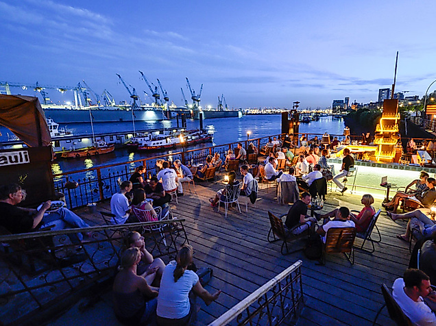 Abendliche Sommerstimmung im StrandPauli in Hamburg mit Blick auf den Hafen und entspannter Outdoor-Gastronomie.