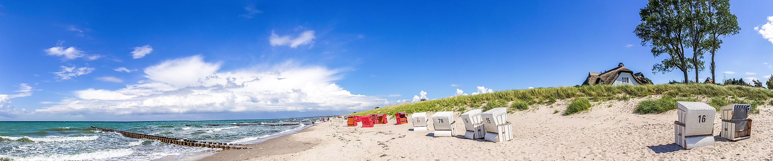 Panorama vom Ostseestrand in Ahrenshoop mit Strandkörben, Dünen und weitem Himmel bei Sonnenschein