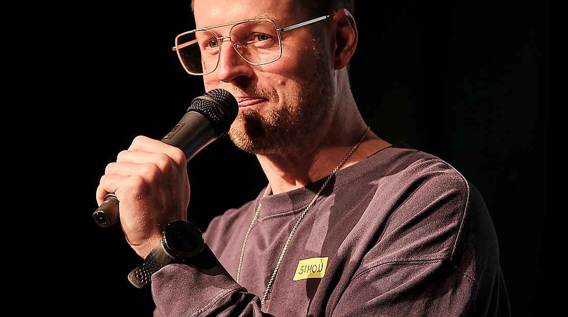 Comedian beim BCC mit Mikro in der Hand