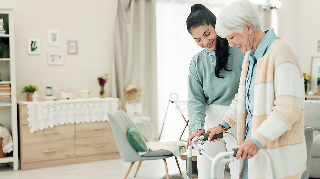 young-woman-helping-senior-with-walker-indoors-2026-09-24-12-49-38-utc