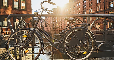 Fahrräder auf Brückengeländer vor historischer Backsteinarchitektur in der sonnigen Speicherstadt