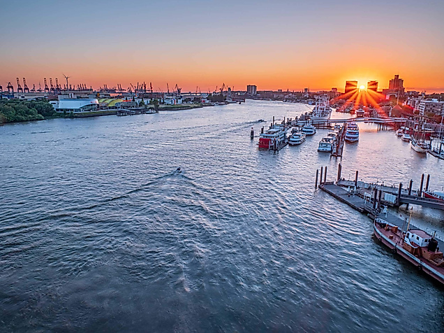 Sonnenuntergang über dem Hamburger Hafen mit glitzernder Elbe und romantischer Abendstimmung