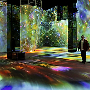 Zwei Personen in bunter Lichtinstallation im Port des Lumières, Hamburgs Zentrum für immersive Kunst