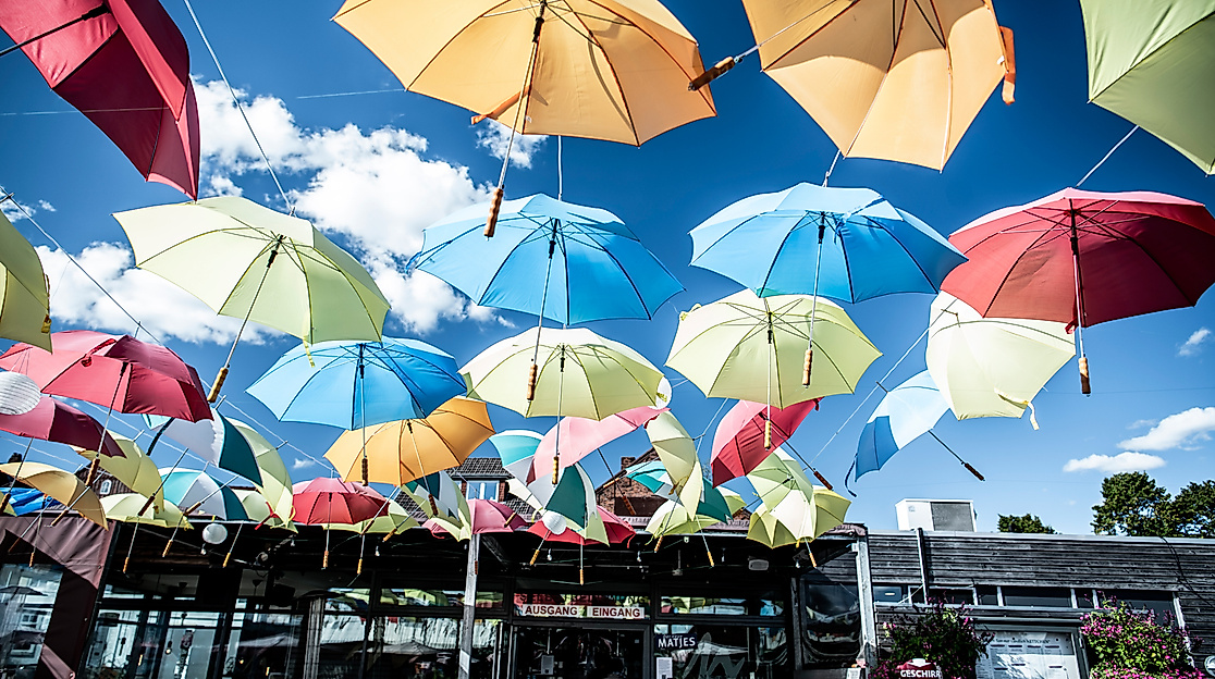 Schwebende Regenschirme über dem Café