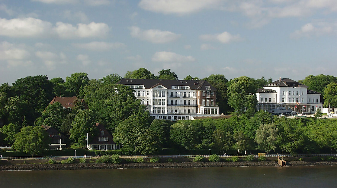 Elbvillen in Blankenese mit Blick vom Wasser auf grüne Uferhänge und historische Architektur.