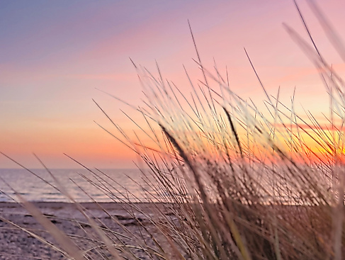 Die Ostsee mit Sonnenaufgang und Dünen in Scharbeutz/ Haffkrug.