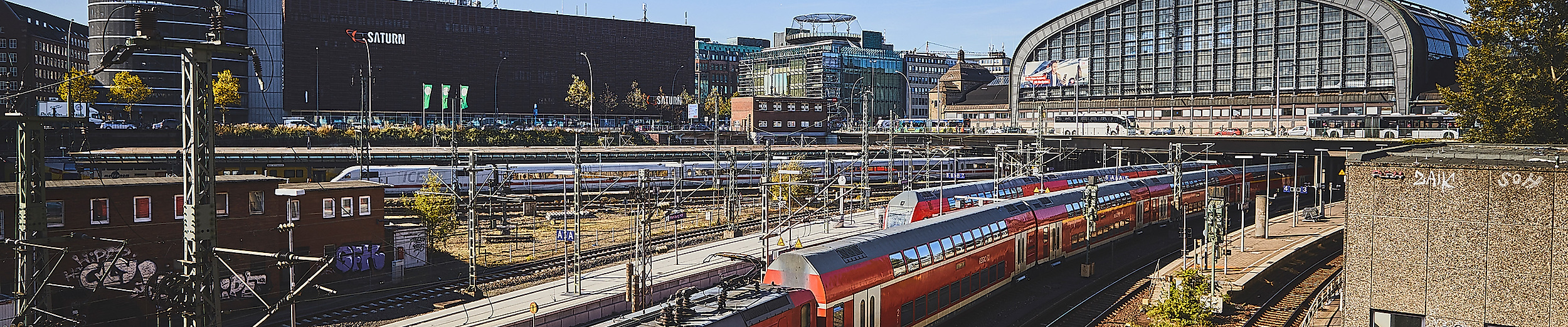 Regionalzug der DB vor dem Hamburger Hauptbahnhof bei Sonnenschein und klarem Himmel.