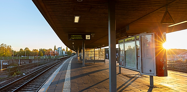 S-Bahn-Station Veddel in Hamburg bei tiefstehender Sonne, mit Bahnsteig, Gleisen und moderner Überdachung