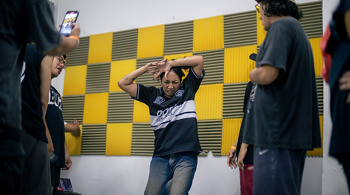 Mehrere Tänzer*innen auf einem Bild, in der Mitte tanzt eine Krump Tänzerin.