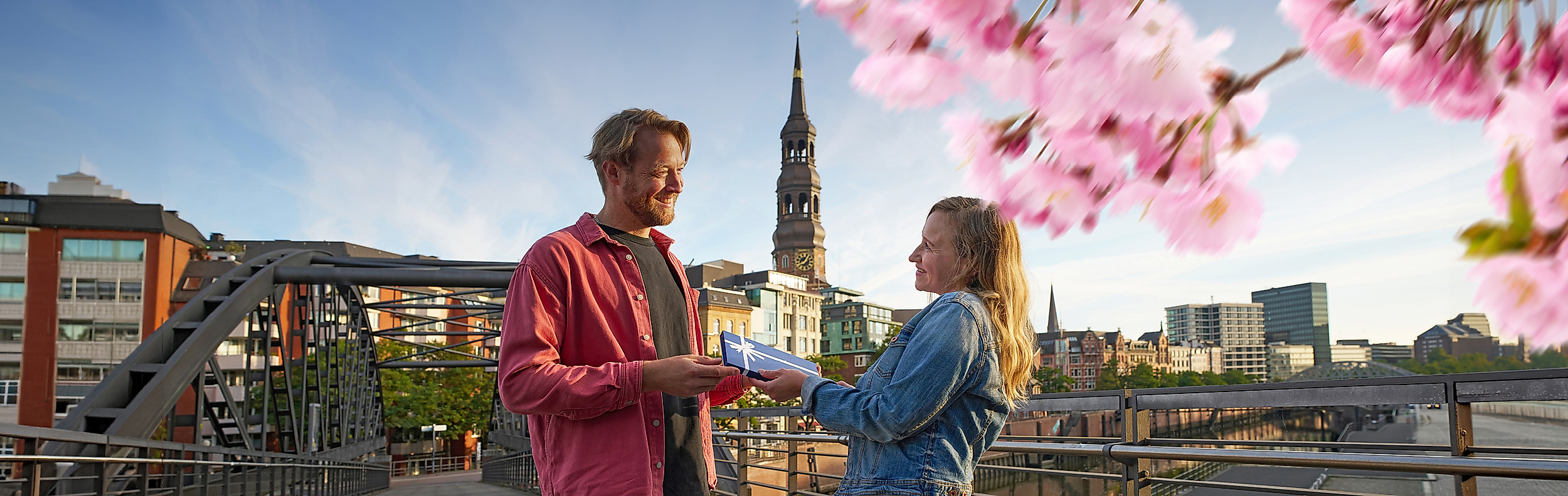 Ein Mann überreicht einer Frau einen Hamburg Gutschein