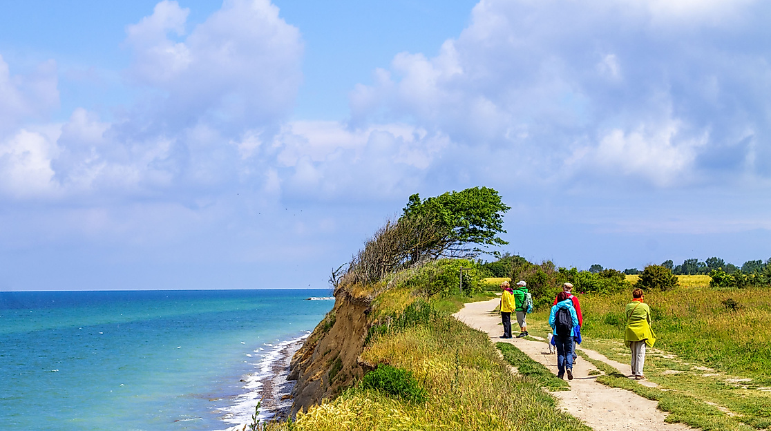 Wandernde Gruppe auf Küstenpfad bei Wustrow mit Blick auf die Ostsee und blühender Natur