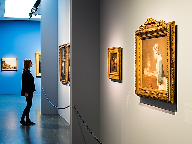 Besucher:in betrachtet Gemälde mit Goldrahmen in der Ausstellung „Die Farben Frankreichs“ in Hamburg 