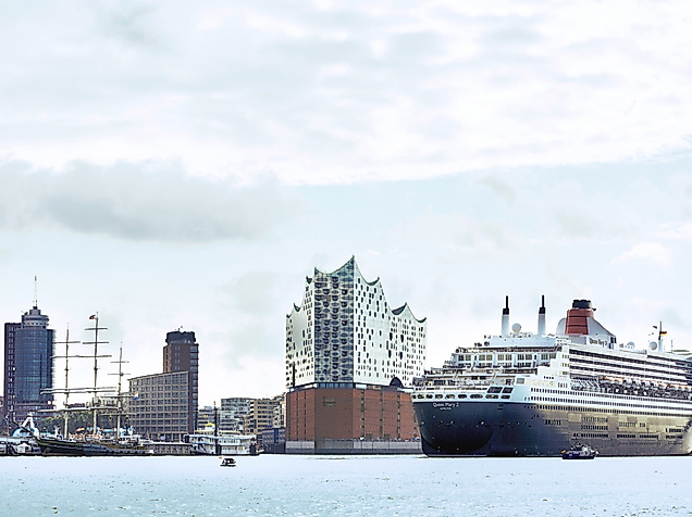 Queen Mary 2 fährt in den Hamburger Hafen ein, im Hintergrund die Elbphilharmonie und Skyline