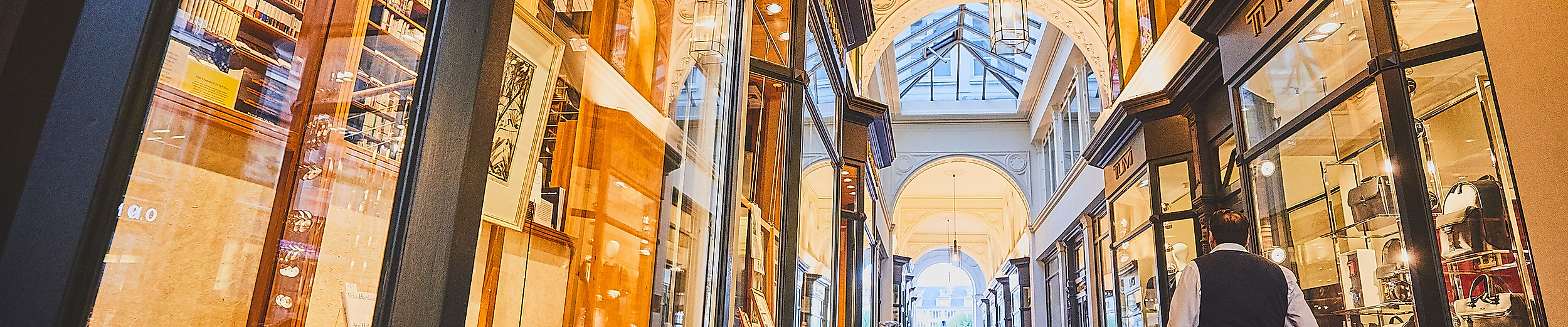Elegante Passage mit historischen Deckenmalereien und Schaufenstern in den Alsterarkaden Hamburg