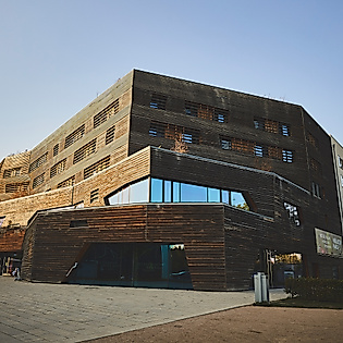 Das Wälderhaus in Hamburg-Wilhelmsburg mit markanter Holzfassade, aufgenommen bei tiefstehender Sonne