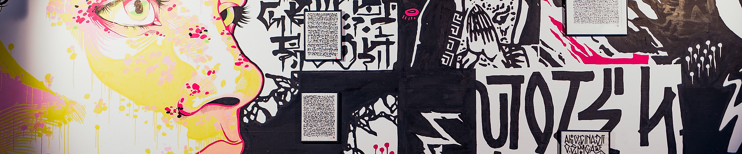 Schwarz-weißes Wandbild mit farbigem Porträt und Schriftzügen bei der Millerntor Gallery in Hamburg.