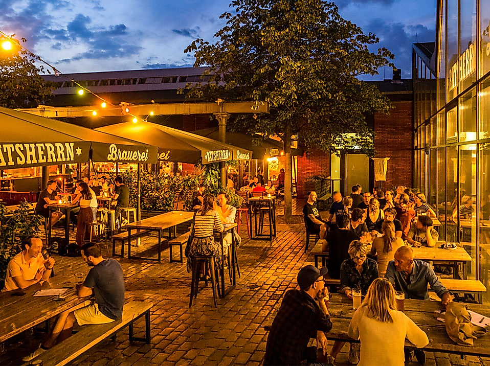 Belebter Biergarten in Hamburg bei Nacht mit stimmungsvoller Beleuchtung und geselligem Treiben