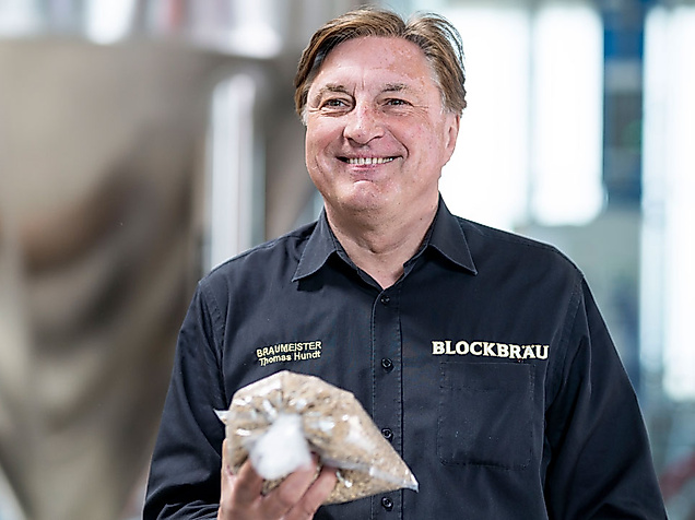 Mann in Brauereibekleidung hält Beutel mit Brauzutaten bei der Hamburg Beer Week
