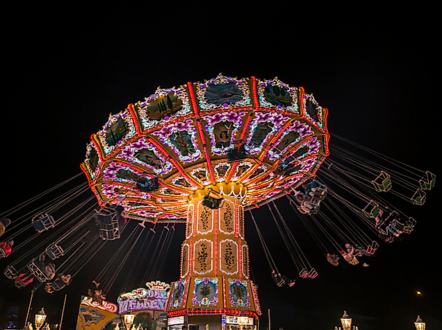 Beleuchtetes Kettenkarussell bei Nacht auf dem Winterdom in Hamburg als festliches Weihnachtserlebnis