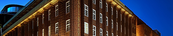Beleuchtete Backsteinfassade des Renaissance Hamburg Hotel am Abend in zentraler Innenstadtlage