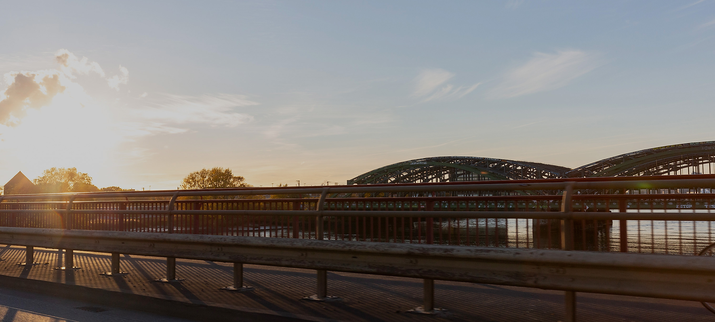 Elbbrücken zwischen Wilhelmsburg und Veddel in Hamburg im Sonnenlicht mit Gleisen und Wasser im Vordergrund