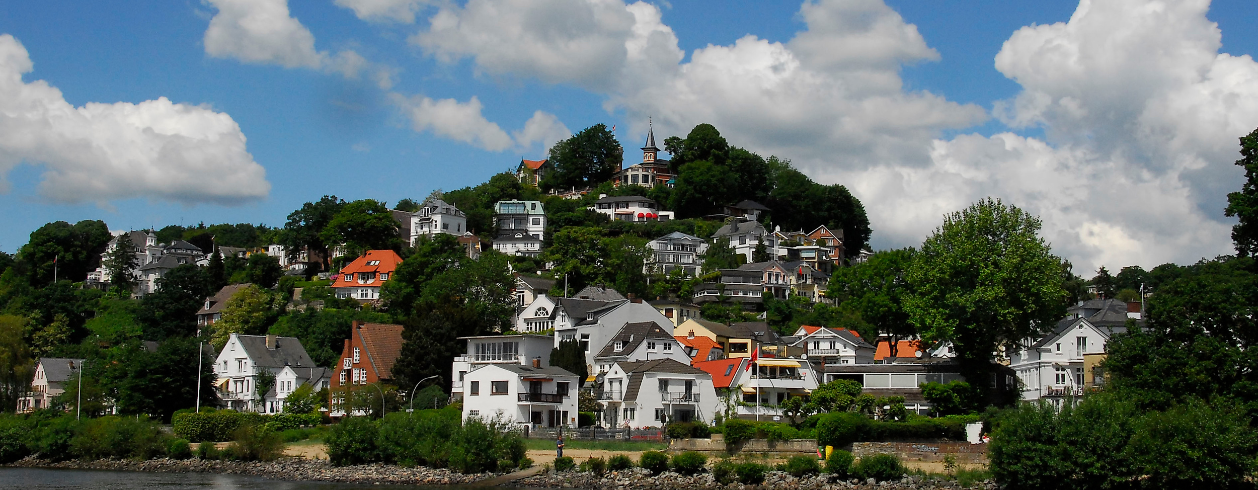 Blick auf das Treppenviertel in Hamburg-Blankenese mit weißen Häusern am Elbhang bei Sonnenschein