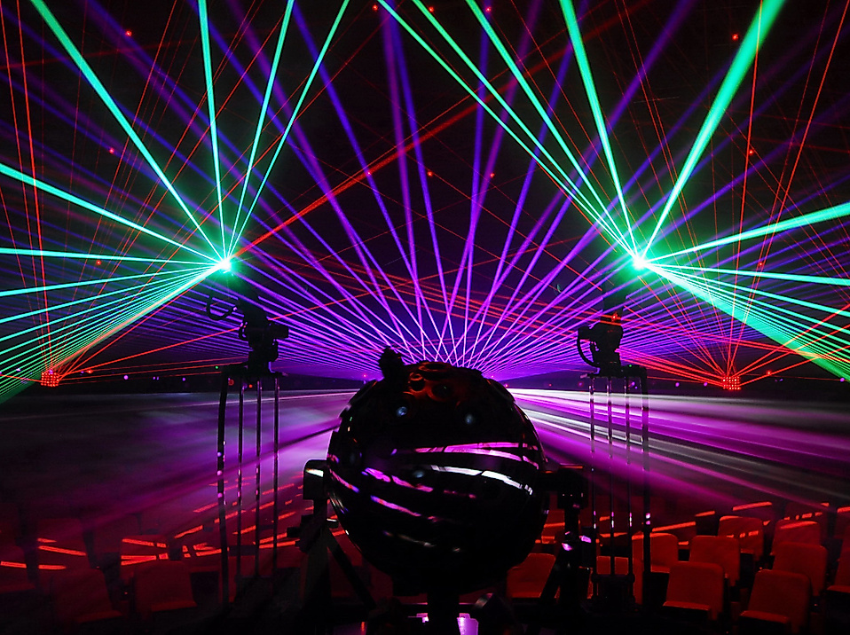 Bunte Lasershow im Kuppelsaal des Planetarium Hamburg mit Projektor im Vordergrund