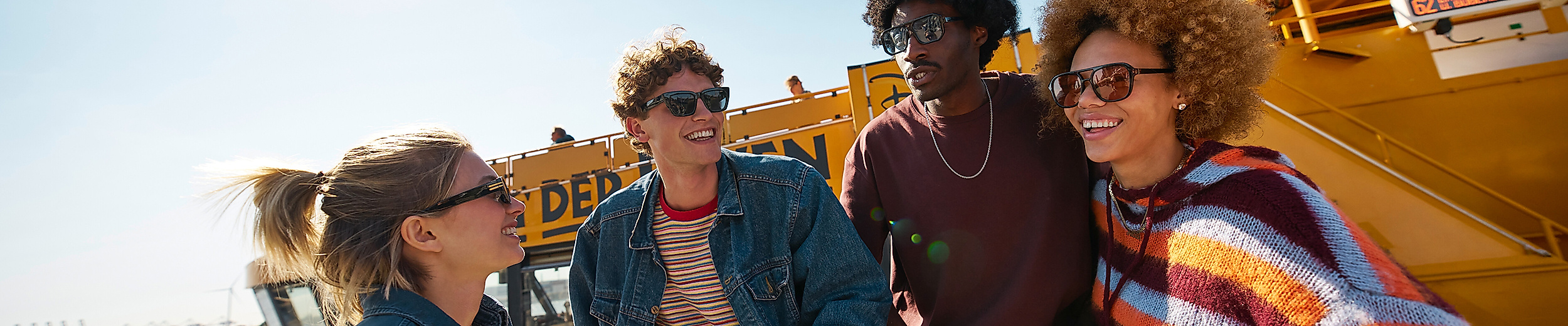 Vier Menschen mit Sonnenbrille vor Hafenfähre in Hamburg