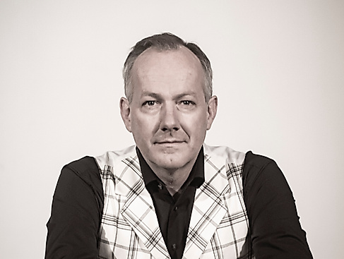 Mann im karierten Anzug auf Stuhl