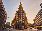 Spitz zulaufende Front des beleuchteten Chilehauses in Hamburg bei Sonnenuntergang