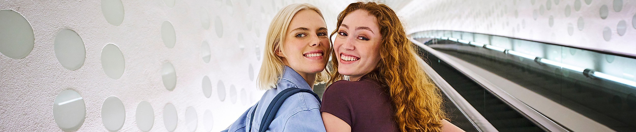 Zwei lachende Frauen auf der Rolltreppe der Elphi.