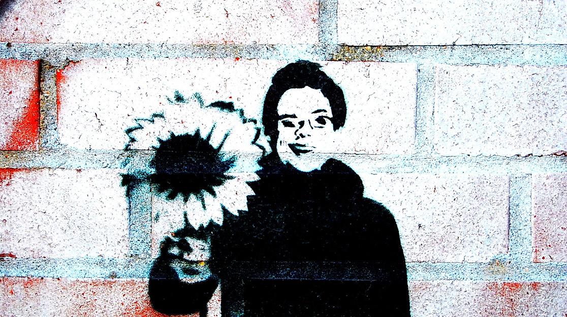 Street-Art-Porträt mit Sonnenblume auf Backsteinwand im Hamburger Stadtraum
