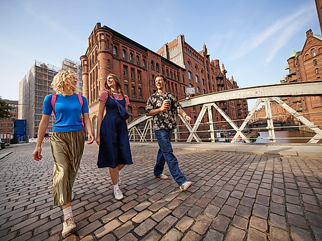 Drei junge Erwachsene gehen in der Speicherstadt spazieren
